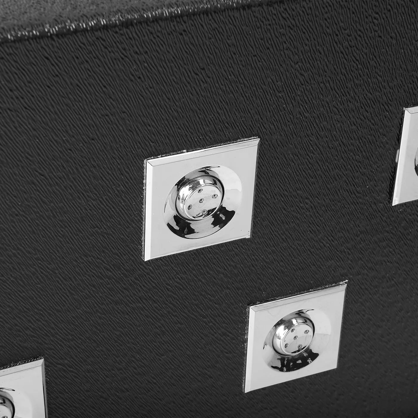 Close-up of chrome hydromassage jets set into the black textured wall of the pet tub